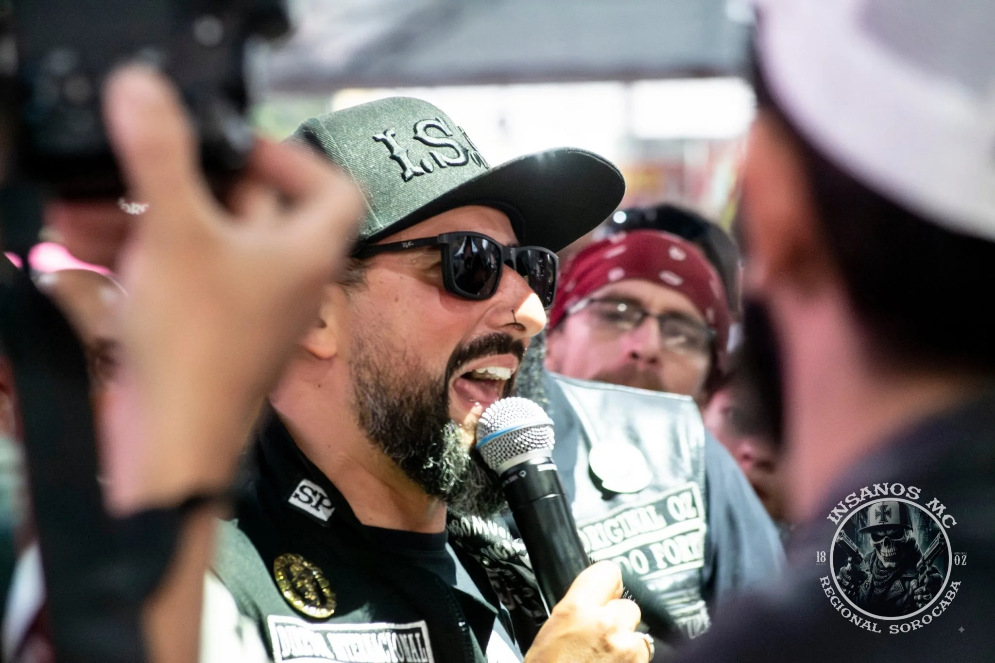 Diretor internacional do Insanos MC ao microfone cercado por integrantes